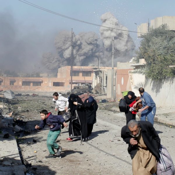 Civili in fuga durante un bombardamento a Tahir