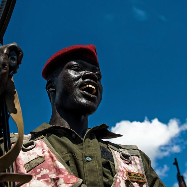 una persona con divisa militare tiene un'arma in mano. sud sudan.