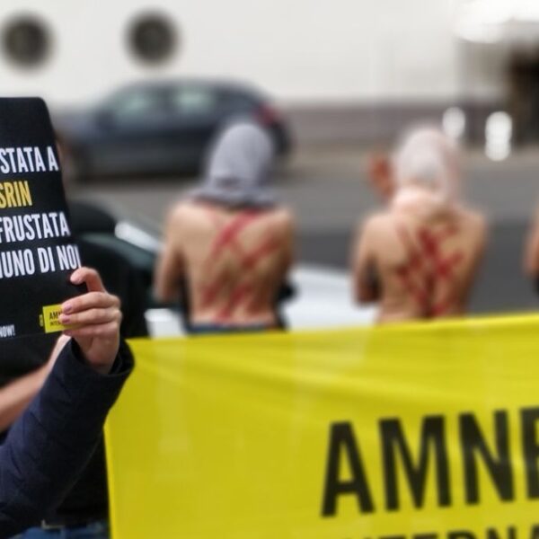manifestazione davanti all'ambasciata iraniana a Roma. SI vedono persone con la schiena scoperta e dei segni a ricordare quelli delle frustate.